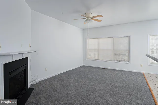 a view of an empty room with a fireplace and a window