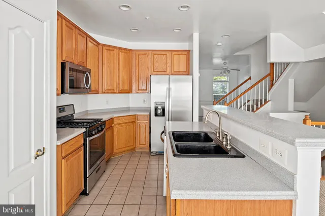a kitchen with stainless steel appliances a stove a sink and a refrigerator