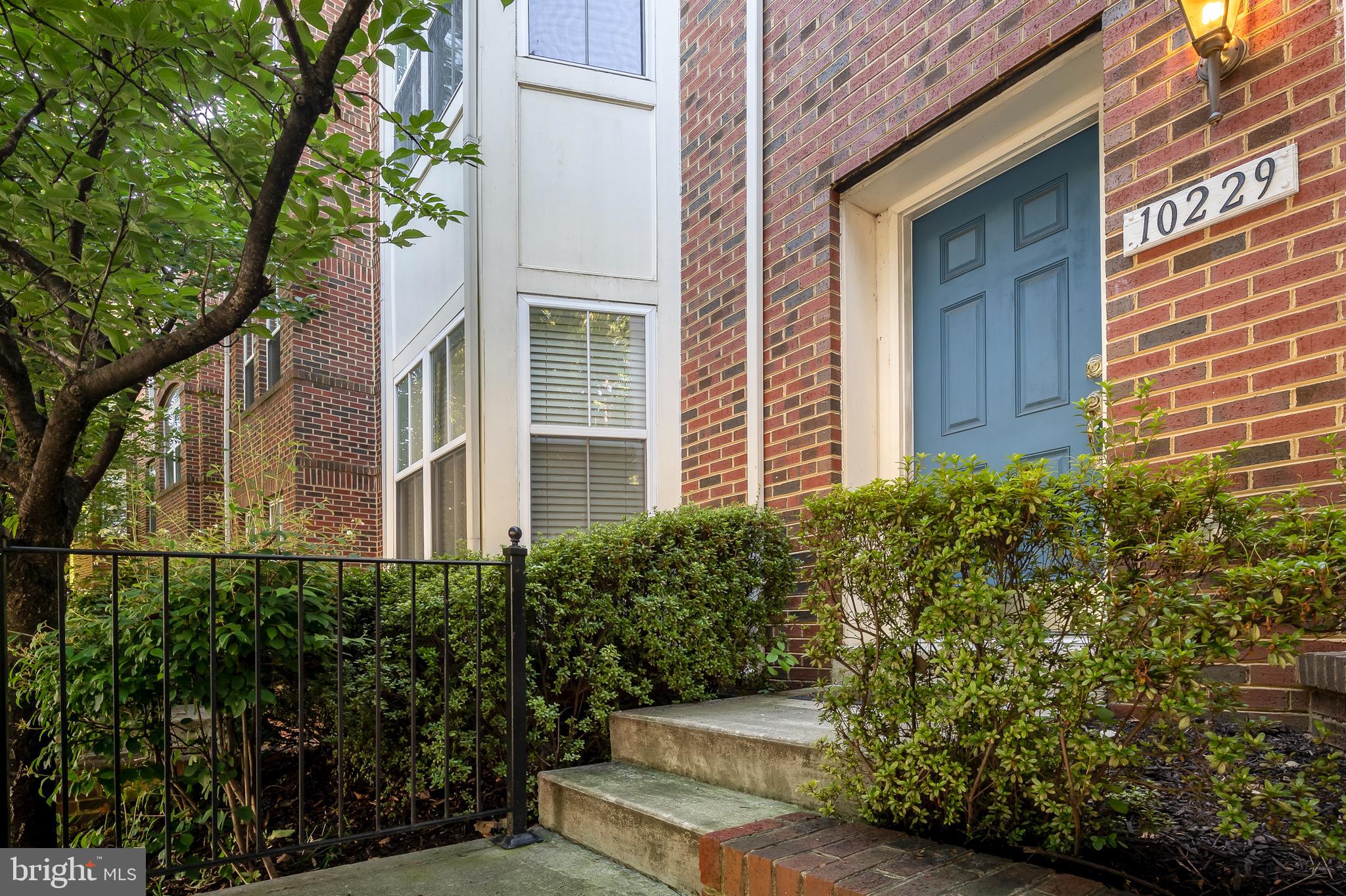 10229 Brighton Ridge Way, Unit 116 Columbia, MD 21044 - Photo 2 of 31 a view of a building with potted plants and large trees