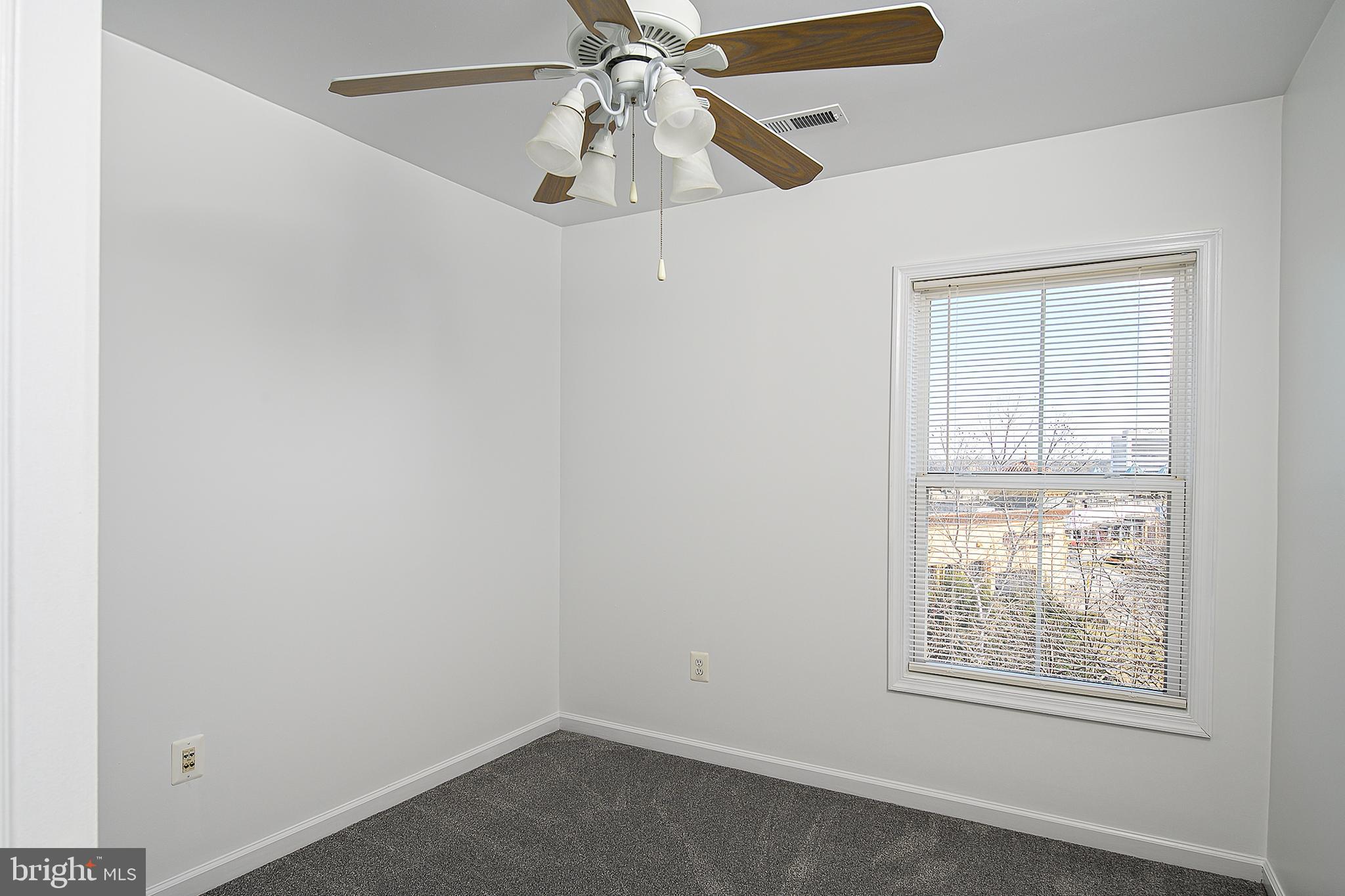 10229 Brighton Ridge Way, Unit 116 Columbia, MD 21044 - Photo 28 of 31 an empty room with windows and fan