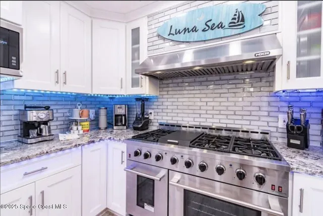 a kitchen with granite countertop stainless steel appliances a stove and a sink