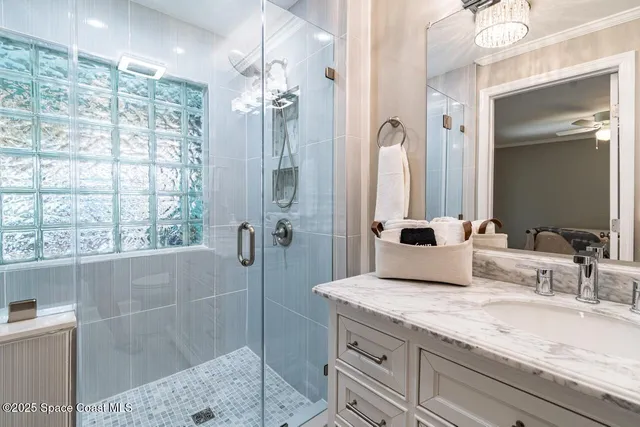 a bathroom with a granite countertop sink a mirror and a shower