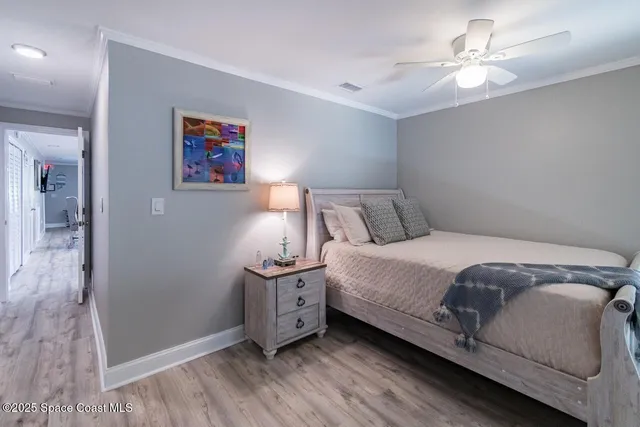 a bedroom with a bed and a ceiling fan