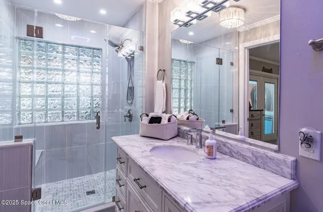 a bathroom with a granite countertop sink a large mirror and shower