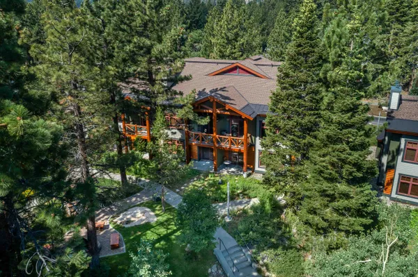 an aerial view of a house with a yard and table chairs
