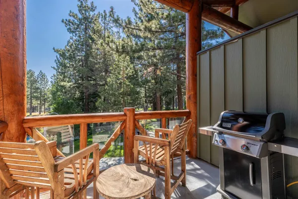 a view of a balcony with furniture and next to a yard