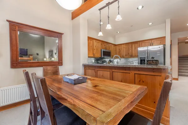 a dining table with chairs and kitchen view