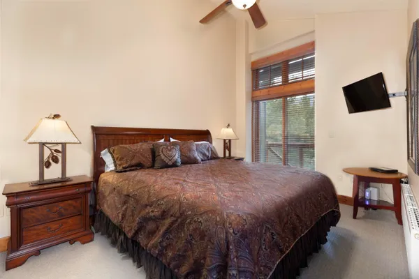 a bedroom with a bed and large window