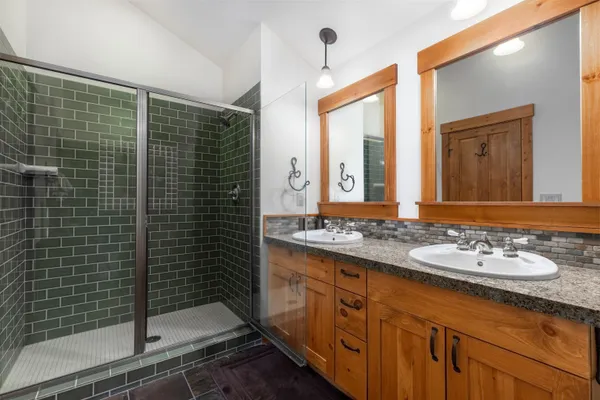 a bathroom with a granite countertop sink a toilet a mirror and shower