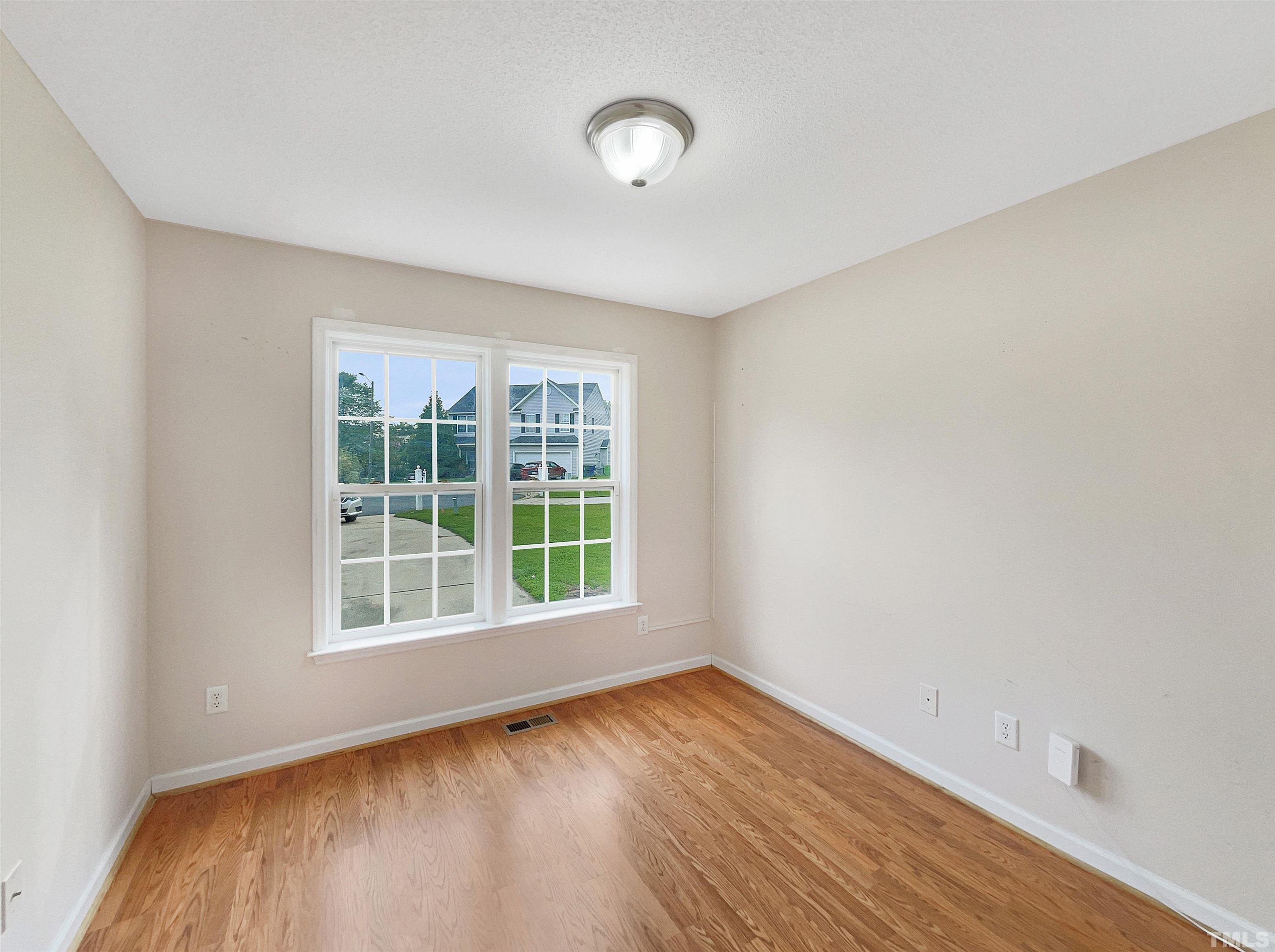 3626 Enduring Freedom Drive Raleigh, NC 27610 - Photo 12 of 17 an empty room with wooden floor and windows