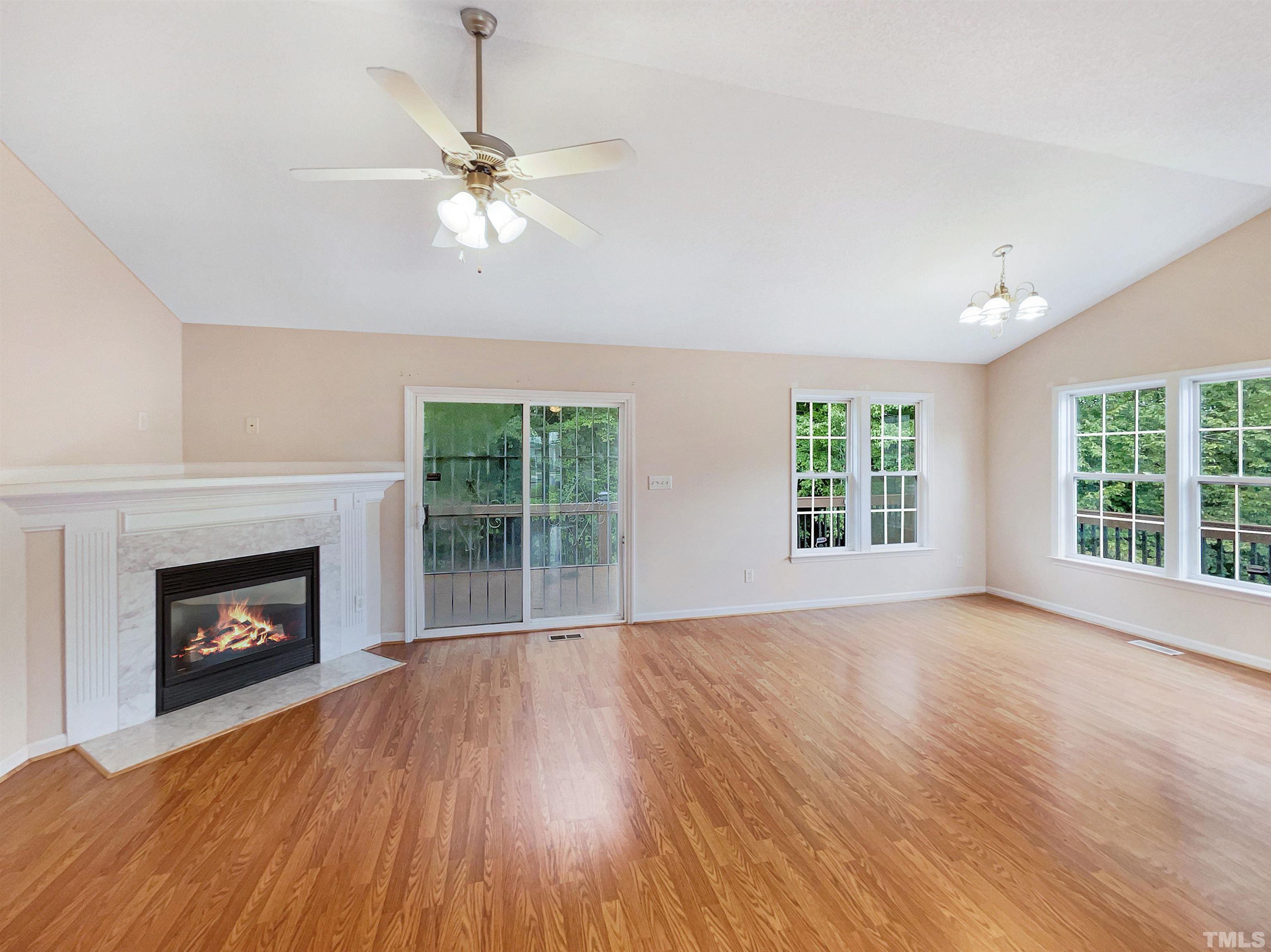 3626 Enduring Freedom Drive Raleigh, NC 27610 - Photo 3 of 17 a view of an empty room with wooden floor fireplace and a window