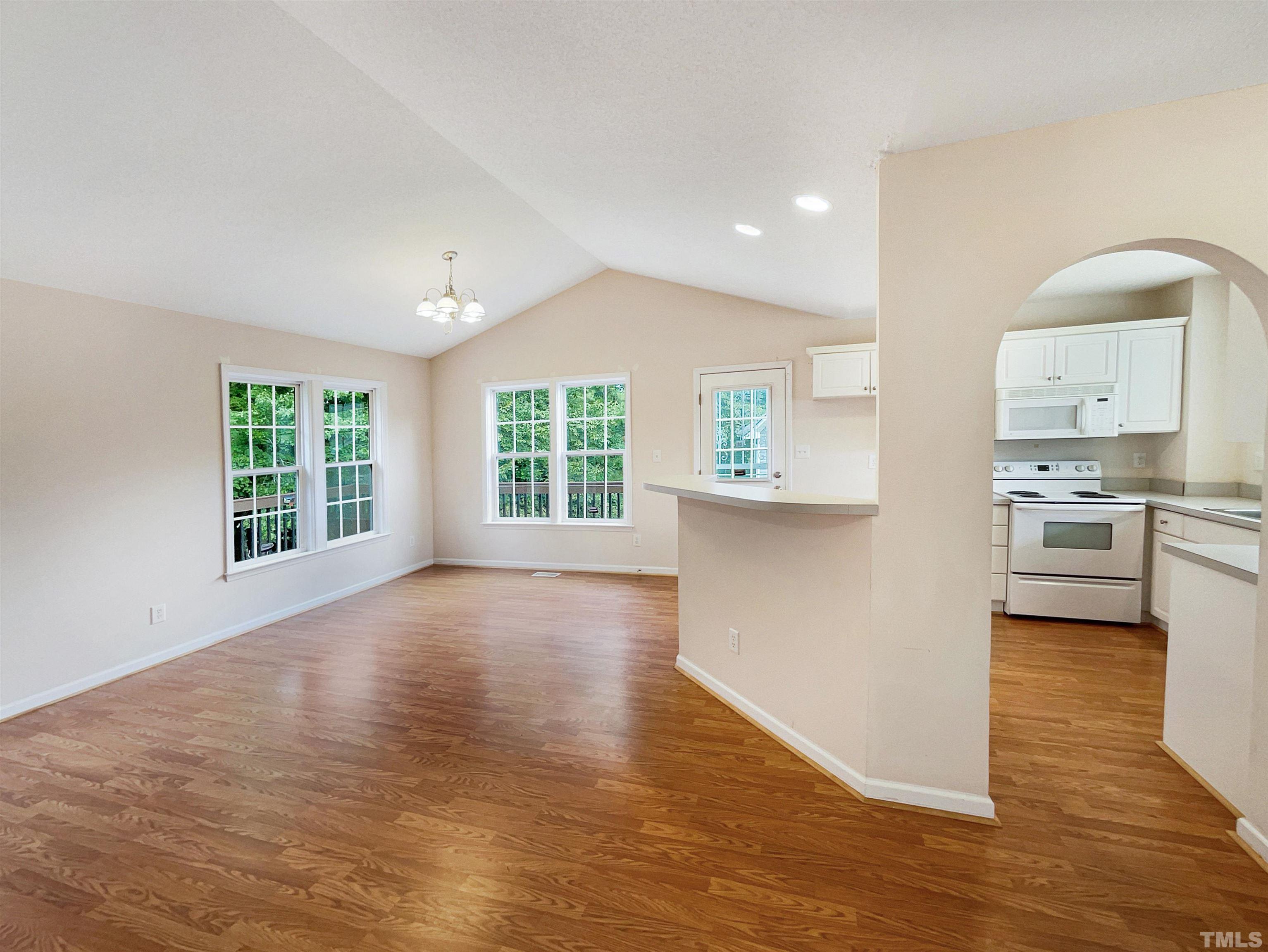 3626 Enduring Freedom Drive Raleigh, NC 27610 - Photo 7 of 17 a view of a kitchen with kitchen island wooden floor appliances and windows