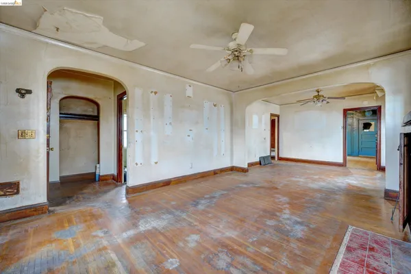 wooden floor fireplace and windows in an empty room