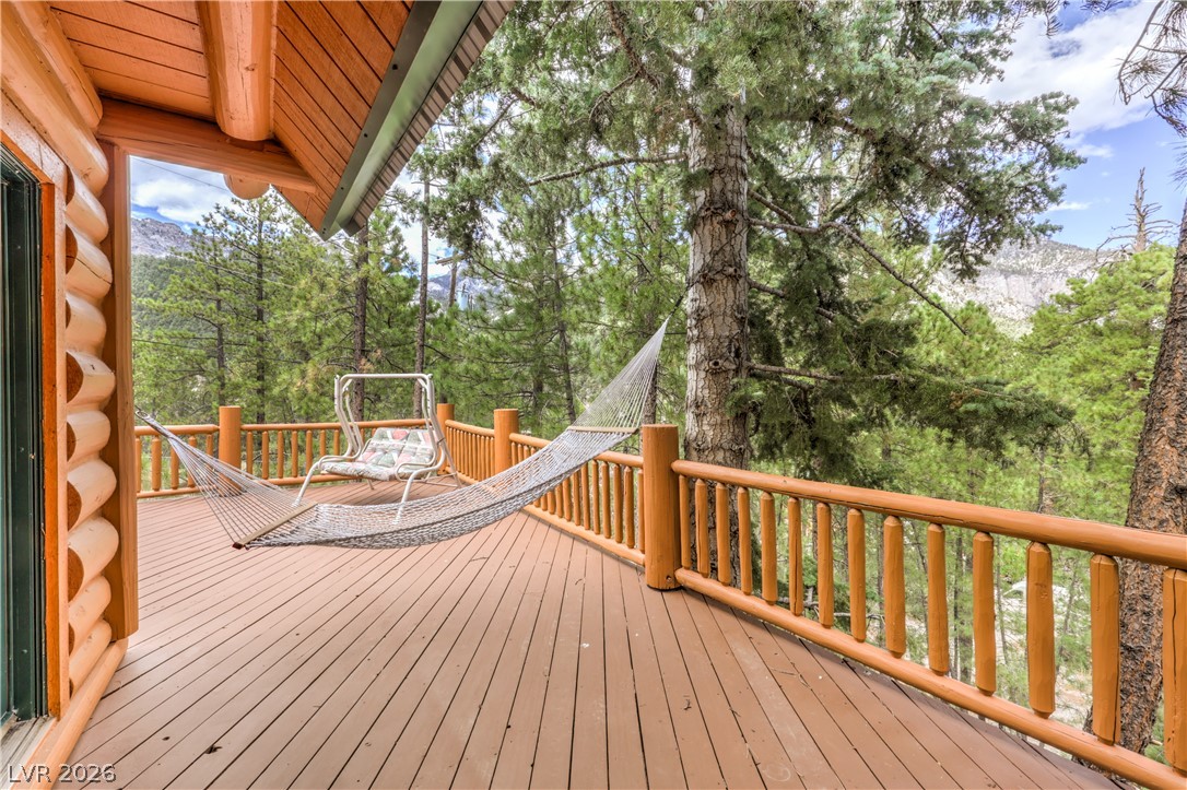 322 Ski Trail Road Mount Charleston, NV 89124 - Photo 36 of 58 Mature trees frame the view from this spacious wooden deck set against a mountain backdrop.