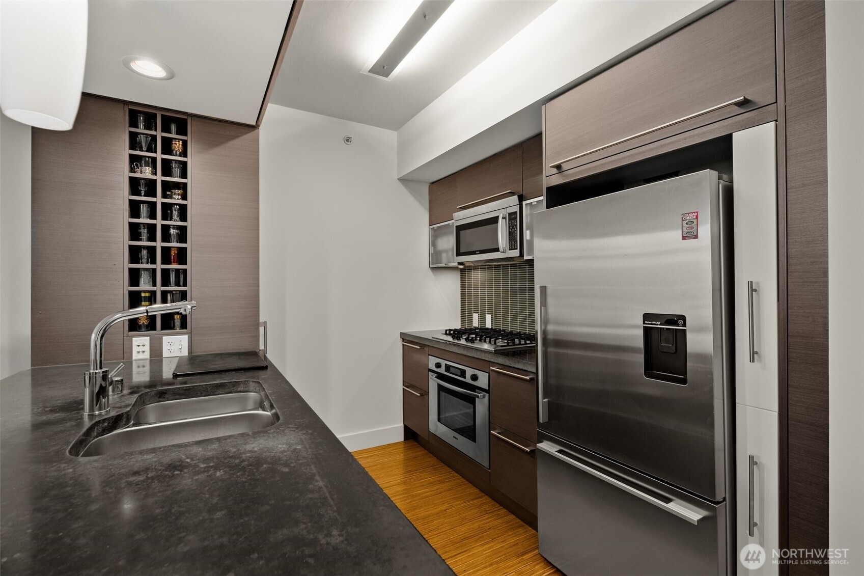 820 Blanchard Street, Unit 1301 Seattle, WA 98121 - Photo 12 of 29 a kitchen with granite countertop a refrigerator and cabinets