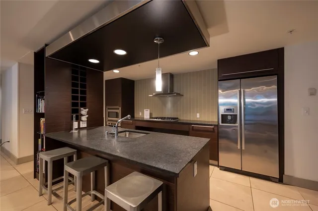 a kitchen with kitchen island a counter space a sink appliances and cabinets