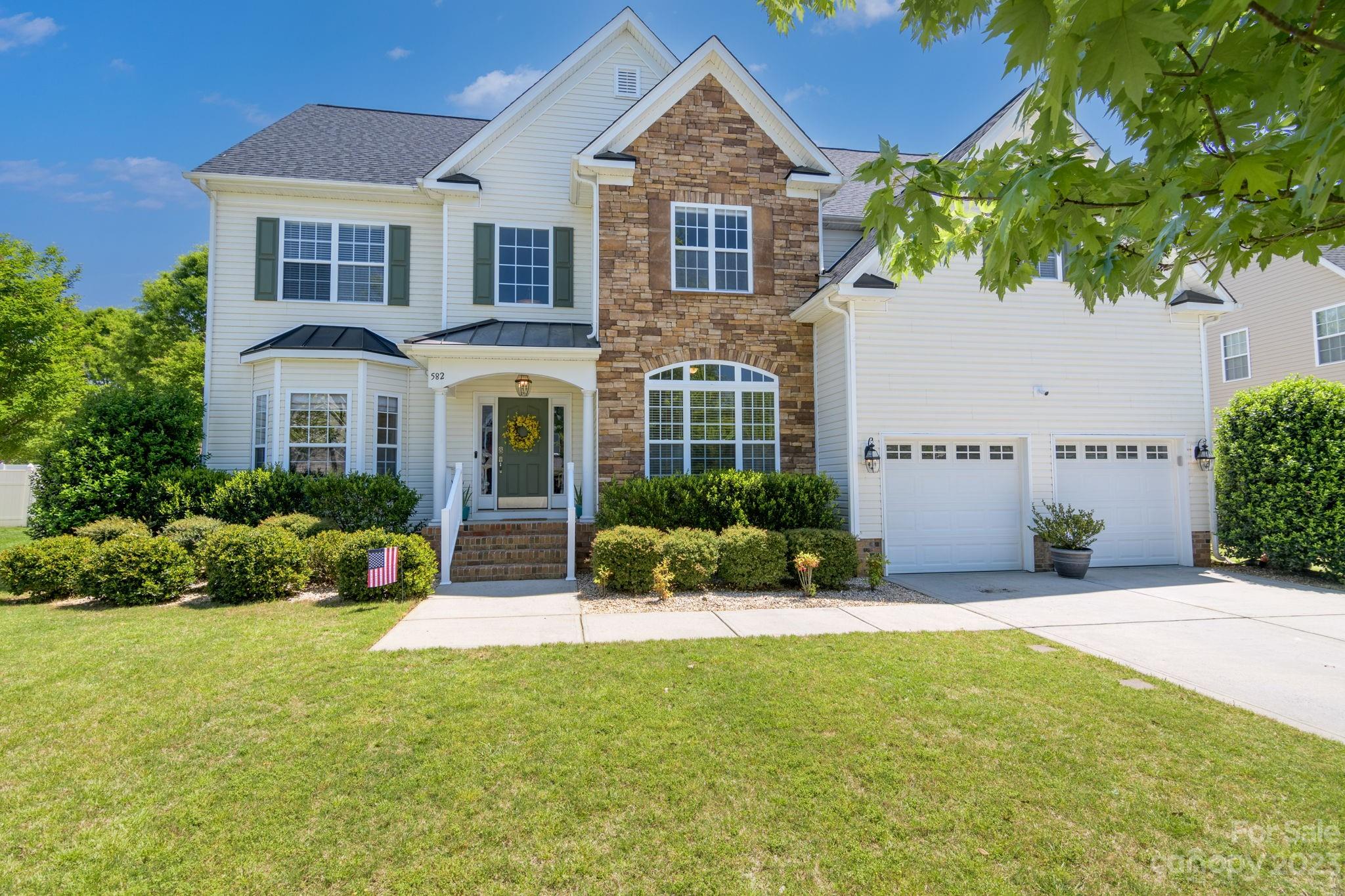 a front view of a house with a yard and potted plants