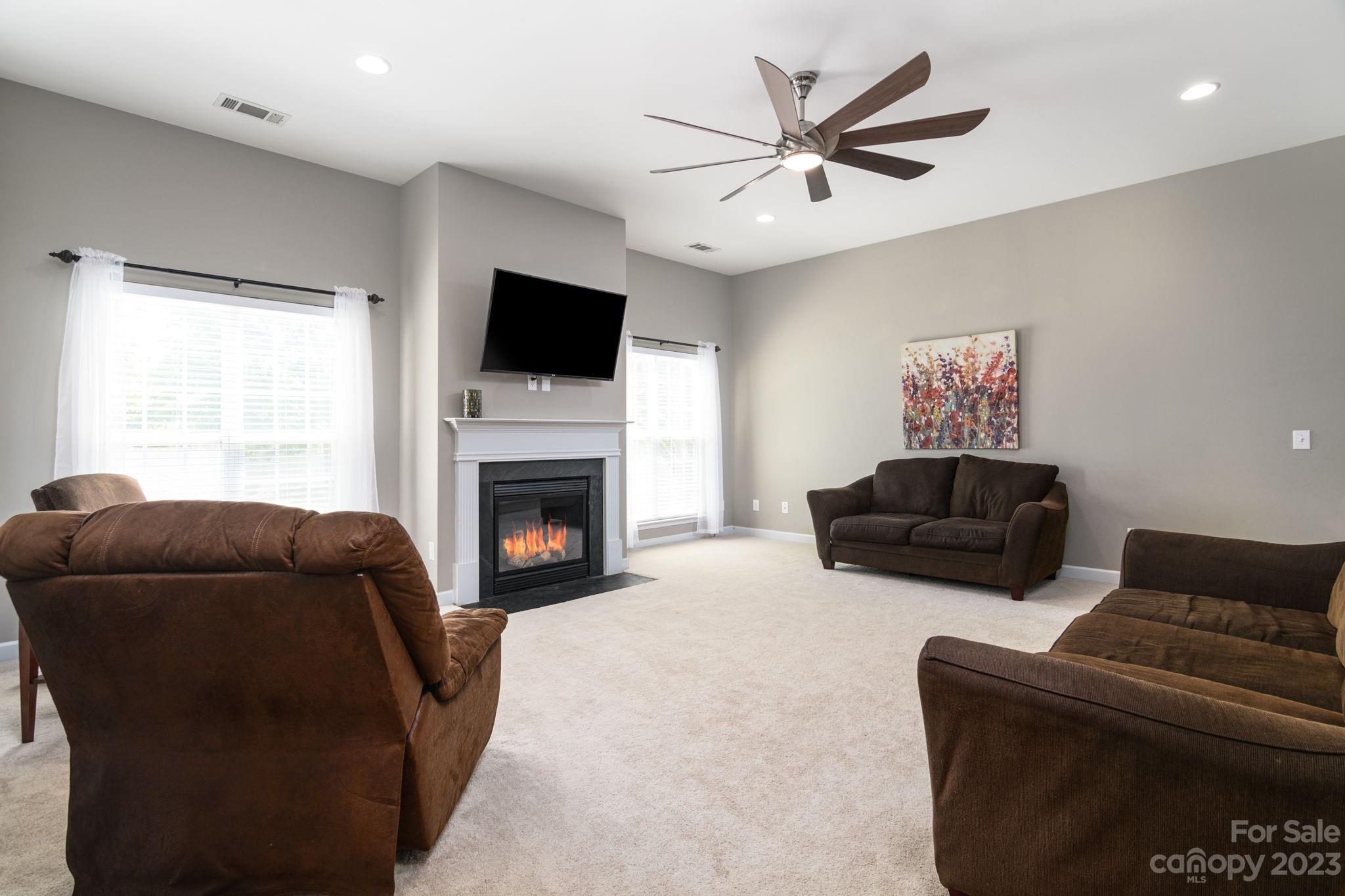 582 Evening Mist Drive Fort Mill, SC 29708 - Photo 13 of 31 a living room with furniture a flat screen tv and a fireplace
