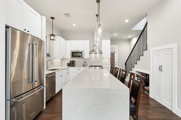 a kitchen with sink a refrigerator and wooden floor