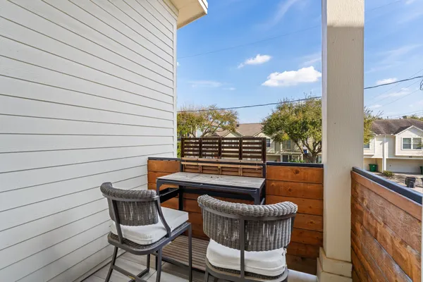 a balcony with table and chairs