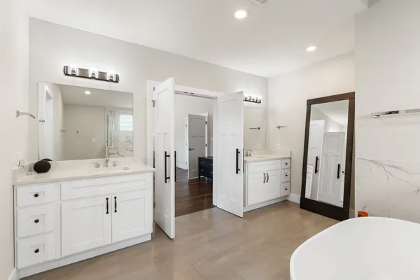 a en suite bathroom with a double vanity sink a large mirror and a shower