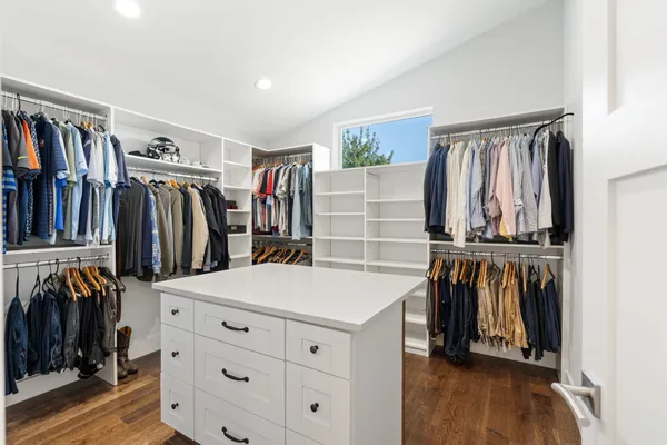 a view of walk in closet with clothes and shoes