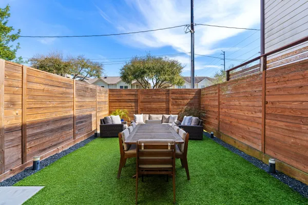 a view of a chairs and table in the backyard