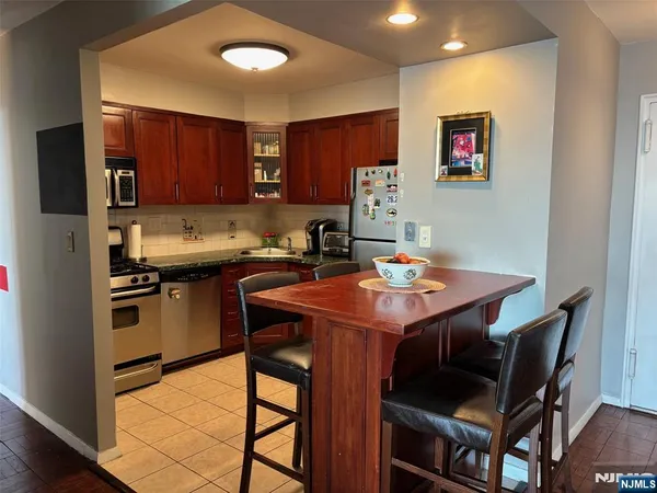 a kitchen with a dining table chairs and refrigerator