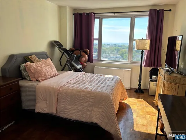 a bedroom with a bed and a flat tv screen on a dresser