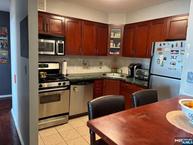 a kitchen with stainless steel appliances a stove a sink a microwave and a refrigerator