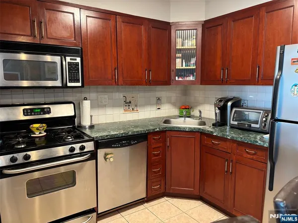 a kitchen with stainless steel appliances granite countertop wooden cabinets a stove a sink and dishwasher