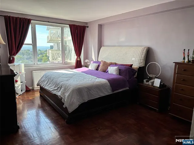 a bedroom with a bed wooden floor and window