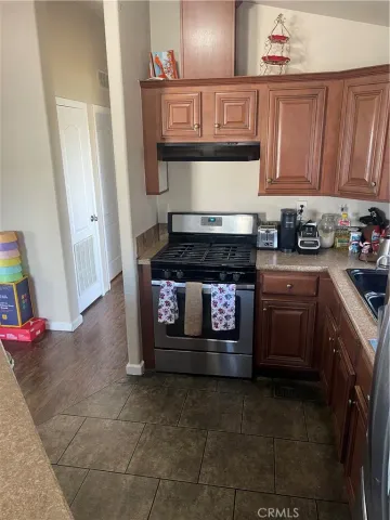 a kitchen with granite countertop a stove top oven and cabinets