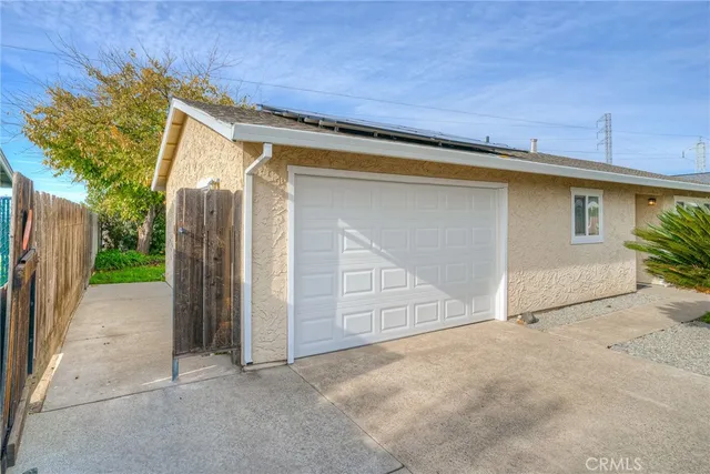 a front view of a house with a garden and trees
