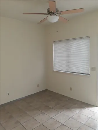 an empty room with a ceiling fan and carpet