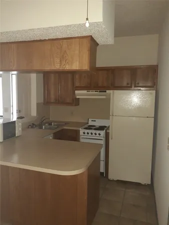 a kitchen with a sink a stove and a refrigerator