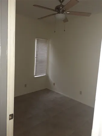an empty room with a window and a fan