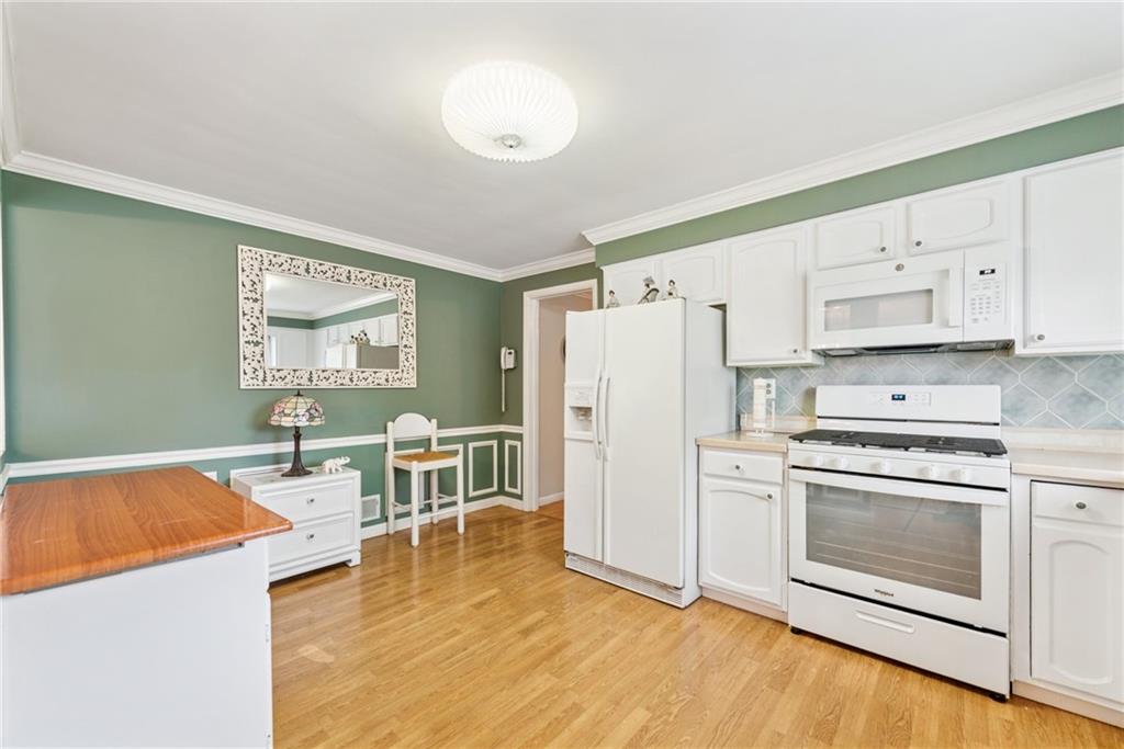 145 Herbst Road Coraopolis, PA 15108 - Photo 10 of 35 a kitchen with stainless steel appliances a stove a refrigerator and white cabinets with wooden floor