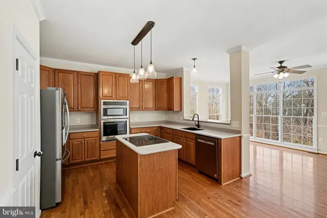 a kitchen with refrigerator a stove and wooden floor