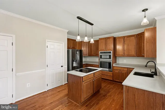 a kitchen that has a sink cabinets counter space and stainless steel appliances