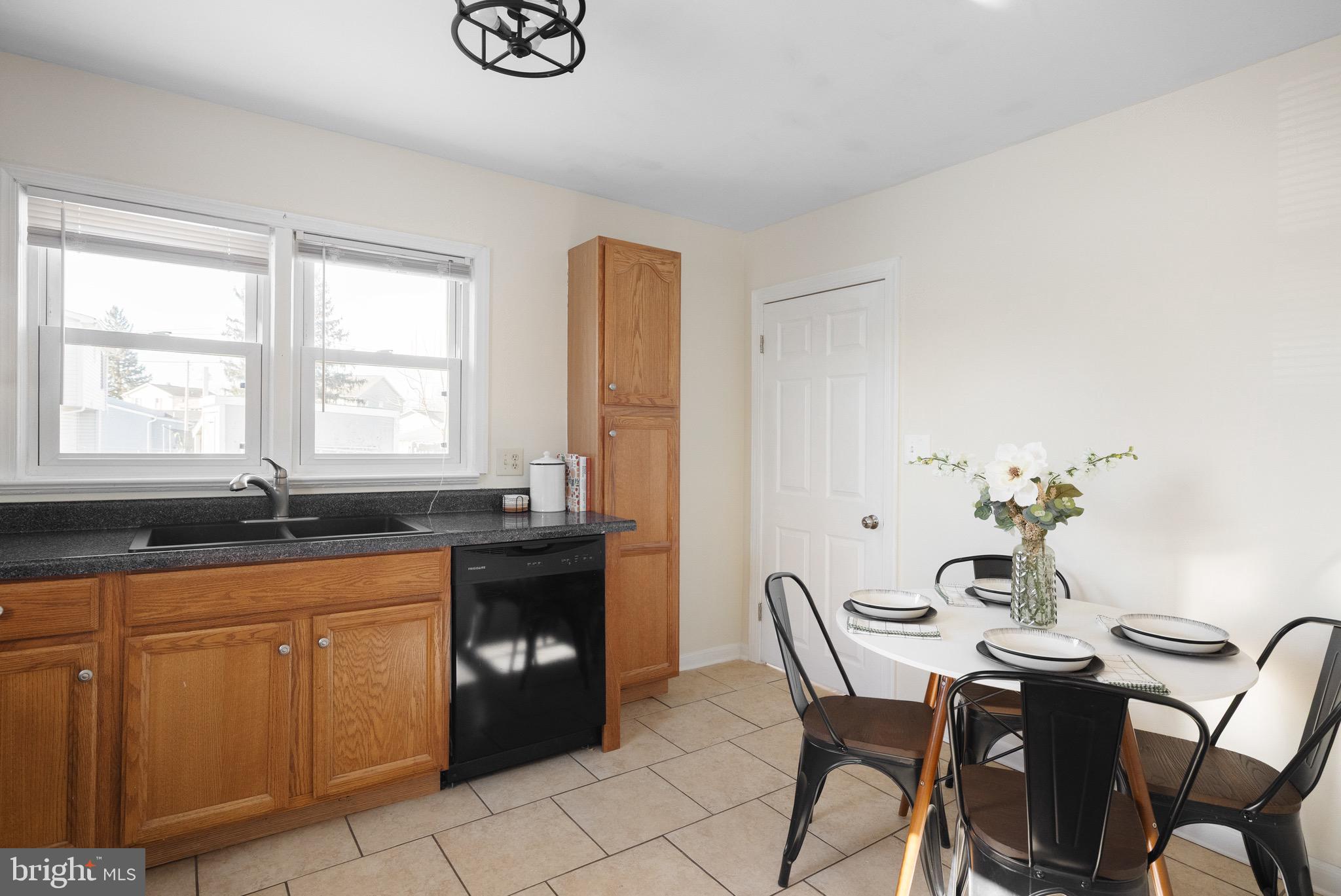 405 East 7th Avenue Ranson, WV 25438 - Photo 7 of 29 a kitchen with granite countertop a sink white cabinets dining table and chairs