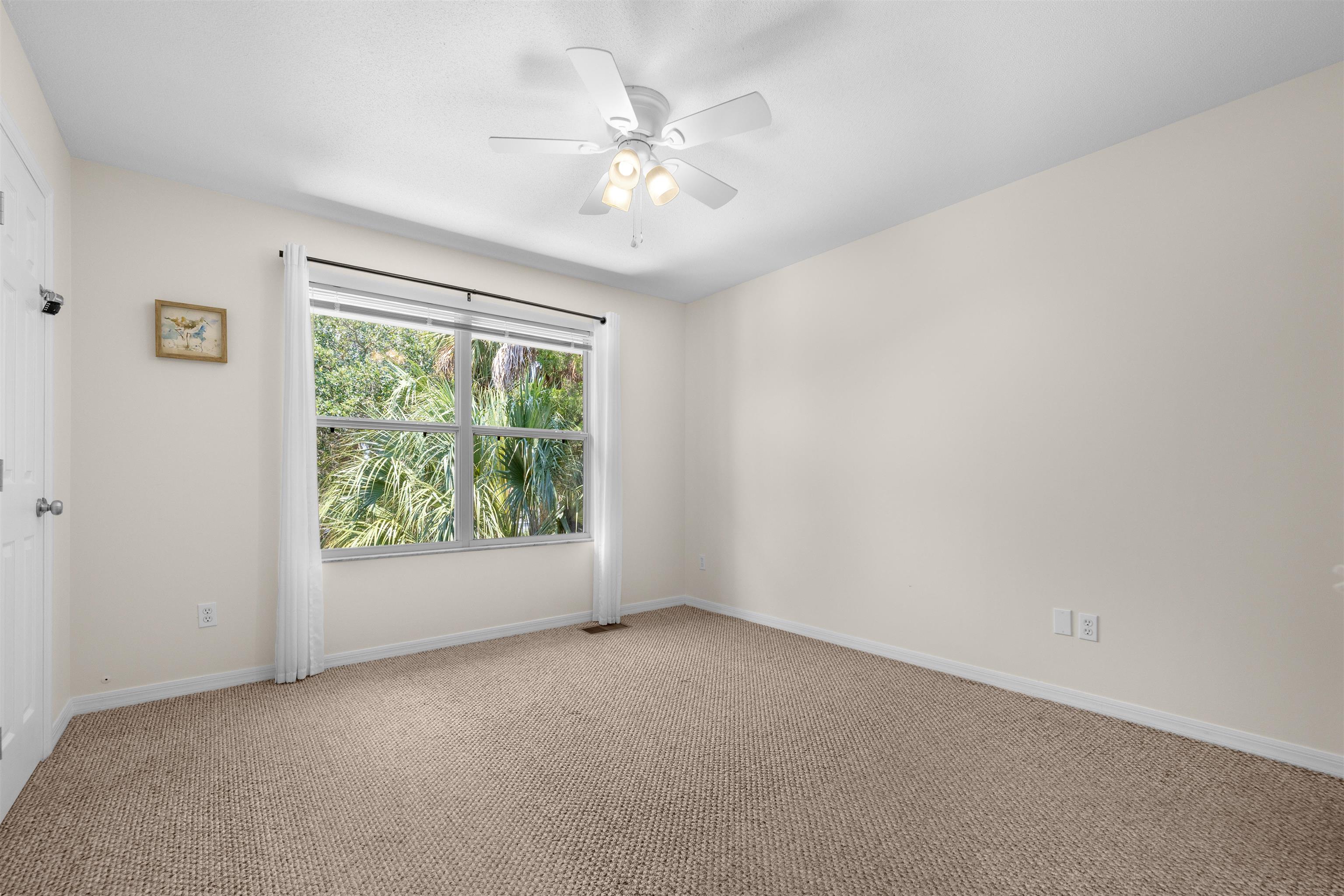 109 B Street, Unit B St. Augustine Beach, FL 32080 - Photo 20 of 30 an empty room with windows and ceiling fan