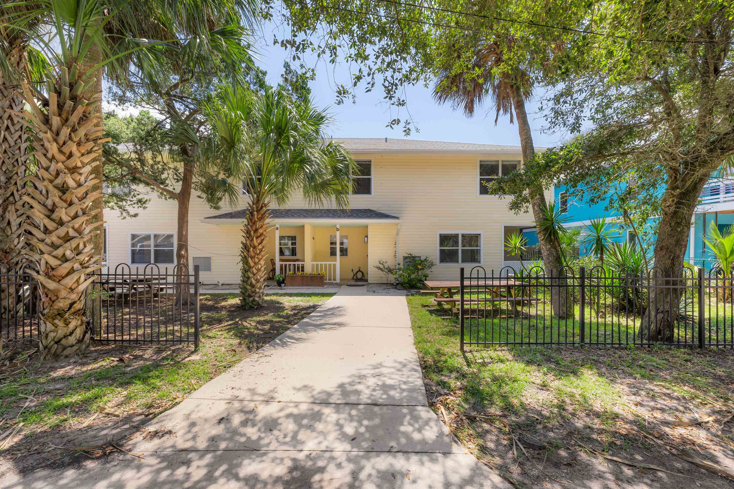 109 B Street, Unit B St. Augustine Beach, FL 32080 - Photo 25 of 30 a view of a white house next to a yard with big trees