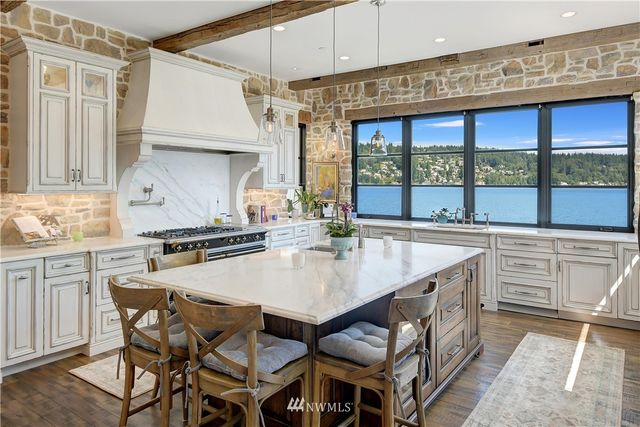 a kitchen with stainless steel appliances granite countertop a stove a sink and a refrigerator