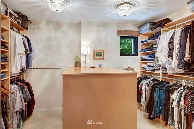 a view of walk in closet with clothes and shoes