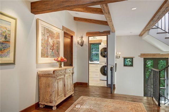 a view of a hallway with wooden floor and windows