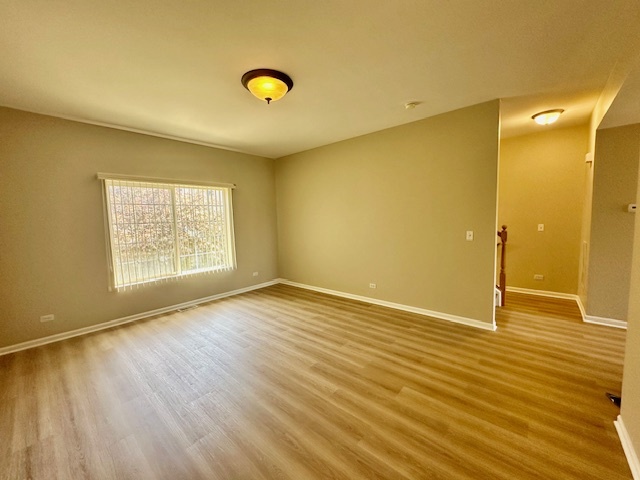 122 Enclave Circle, Unit D Bolingbrook, IL 60440 - Photo 5 of 20 a view of an empty room with wooden floor and a window