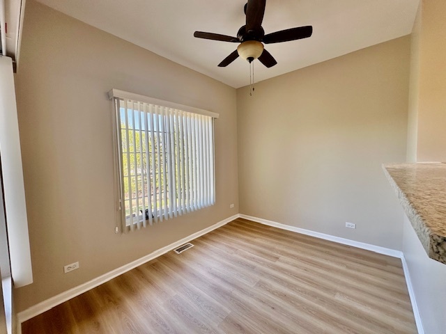 122 Enclave Circle, Unit D Bolingbrook, IL 60440 - Photo 9 of 20 an empty room with wooden floor fan and windows