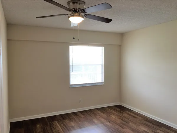 an empty room with a window and wooden floor