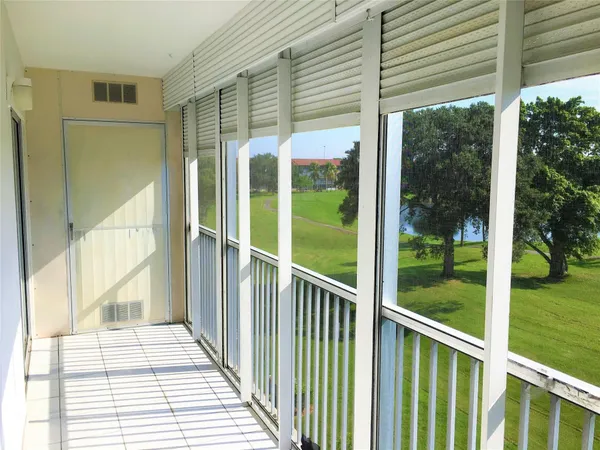 a view of a porch with a floor to ceiling window and wooden floor
